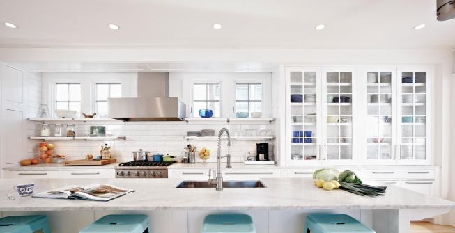 The room's mostly white color palette acts as a backdrop for displayed housewares.