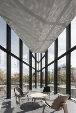 The west end of the building comes to a sharp point that houses seating for a café. The bases of the steel mullions are covered by river rocks to mask imperfections in the construction, and to mark the transition from outside to inside.