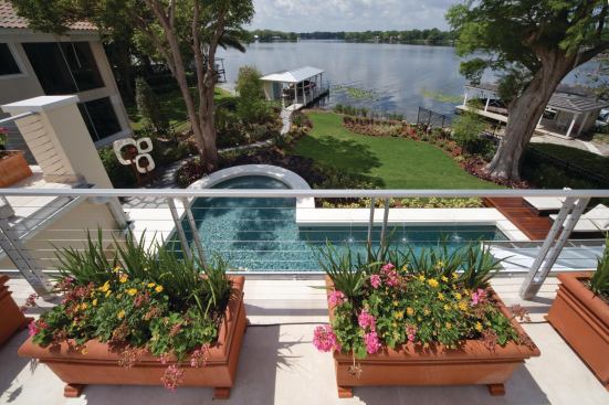 An upper roof deck offers an elevated view of the backyard lake.