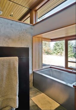Waterproof plaster veneer gives the walls of the bath texture and random movement. Such visual tricks contrast nicely with the vertical-grain woods Prentiss speced.