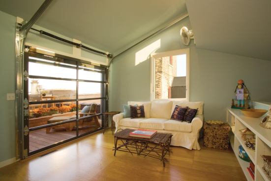 The sunroom’s glazed overhead door opens onto a private rooftop deck.