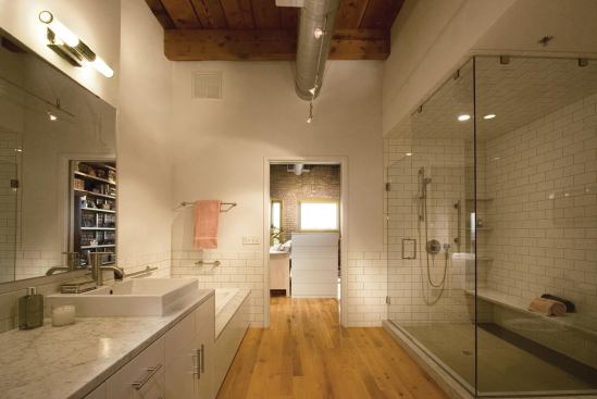 The master bath stresses simplicity, with a continuous marble sink counter/tub deck and subway tile for the wainscot and shower.