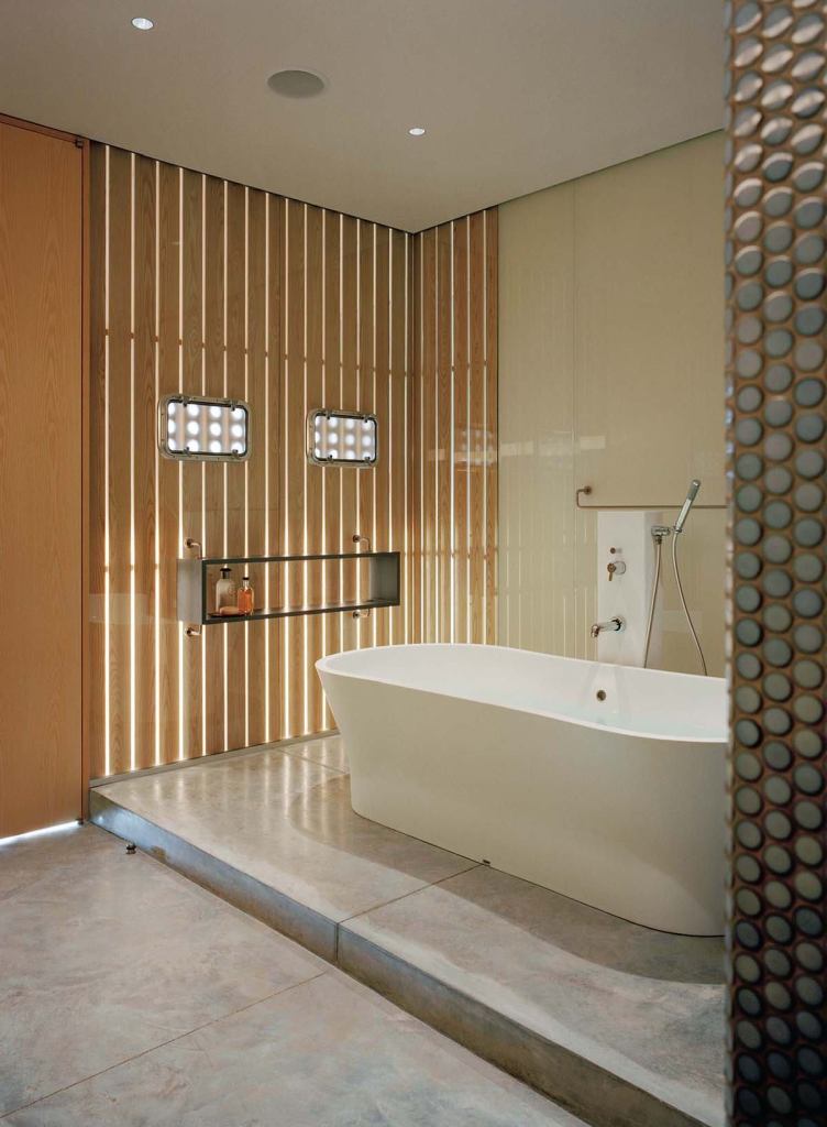 Wood screens add warmth, texture, and natural light to the minimalist master bath. Polished concrete floors reflect light back up into the room.