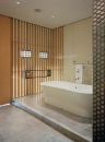 Wood screens add warmth, texture, and natural light to the minimalist master bath. Polished concrete floors reflect light back up into the room.