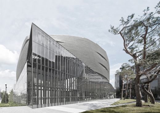 The glazed west corner of the building protrudes into the surrounding plaza.