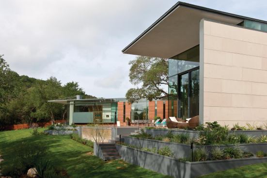 Garden terraces tie the house to the gently sloping yard and act as a stormwater management system.
