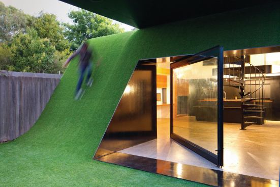 To accommodate a family of five as well as take advantage of what little sun this narrow back yard receives, Maynard placed a two-story addition at the back edge of the site. The lower level kitchen is encased in a hill, which provides the family with lunging and playing space.