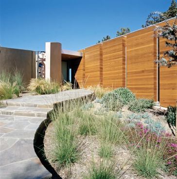 As with many of the firmÕs houses, the quiet front elevation of this La Jolla, Calif., residence (below, left) gives way to a dramatic rear fa?ade (left and below). Clerestory windows let sunlight spill into the interiors.
