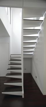 The most dramatic gesture is a white steel staircase replacing the old one in the apartment’s center. The floating stair allows sunlight to wash down over both walls through cantilevered, wenge-topped treads and thin vertical railings.