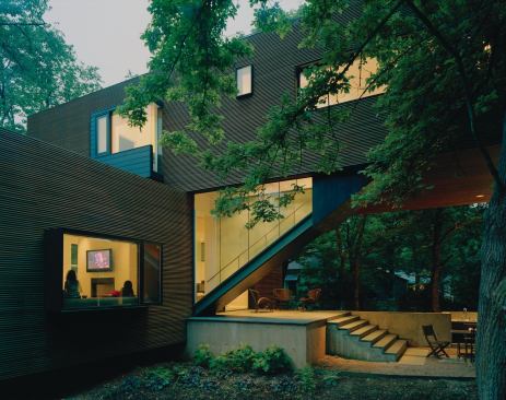 The glass-walled stairway hinges the two volumes together.

