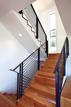 A central staircase (with an assist from a ceiling fan) acts like a chimney to draw cool air through the house from the basement to clerestory windows on the top floor, limiting the use of the central air cooling system to only the hottest days, and then only for a few hours. The relatively low velocity airflow allows the natural convection of cool air to pervade the main level.