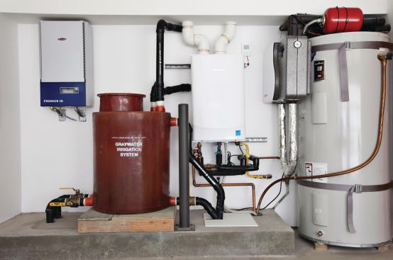 The seldom-used heating and cooling system and backup tankless water heater share space with the red greywater tank. 