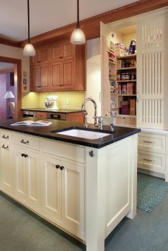 Pantry doors reminiscent of a corn crib contrast with oak cabinetry, and they add a Midwestern farmhouse touch. 