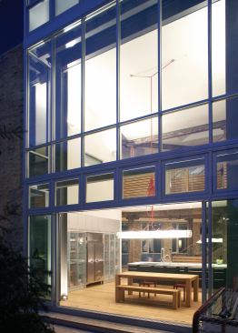 Using off-the-shelf industrial products, such as aluminum windows for the wall of glass that connects the kitchen to the outdoor deck, set off this building’s good looks. Using ready-mades instead of custom materials also helped saved on budget.