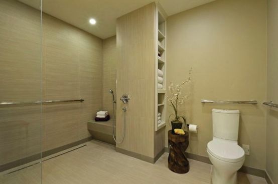 The curbless shower is made with slip-resistant tile.The ADA toilet is pre-plumbed for bidet, and includes grab bars.  