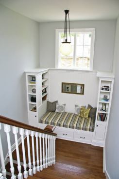 A centrally located stairwell makes this four-square house feel spacious. Interior details such as a daybed, a large window, and bookcases turn a stair landing into a cozy place to read. 