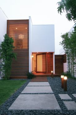 A pivot door gets a special—and a spatial—assist from a slatted wood wing that warms up the modernist look of the outside. The added element embellishes and shelters the entry at the same time. What’s more, the wing helps the front door appear wider and more substantial than it really is in relation to the elevation. 


Rotenberg Residence, Malibu, Calif.; Architect Minarc, Santa Monica, Calif.; Builder Lannen Construction, Los Angeles


