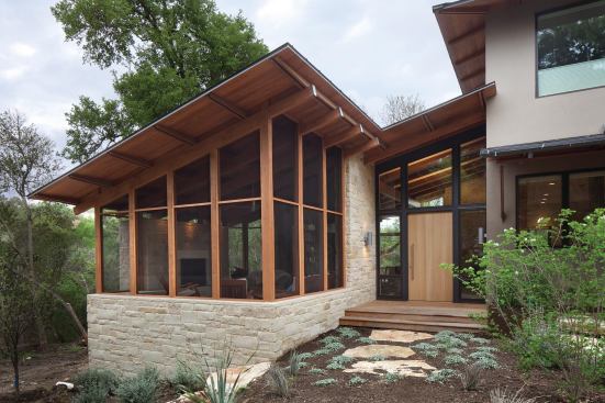 Placing the fireplace inside the screened porch eliminates indoor fumes and a broken thermal envelope.