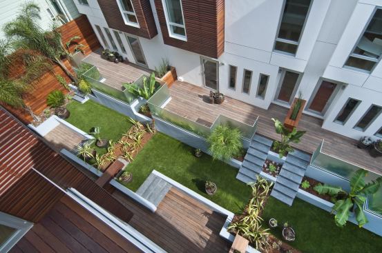 The six buildings are clustered to create an interior courtyard landscaped with drought-tolerant plants and synthetic grass.