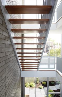 An open-riser staircase lets light penetrate the interiors at 3701 S. Parnell.