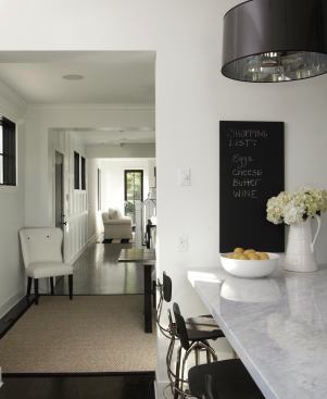 A marble kitchen island has seating on one side and workspace on the side that faces the range.