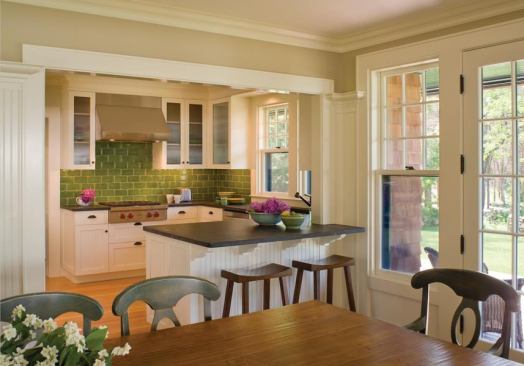 A glass tile backsplash and integral sinks made of concrete add a contemporary touch that makes sense in this shingle-style house.  
