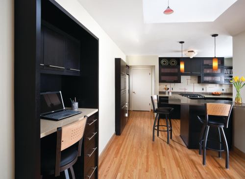 Modern black and white kitchen with built in desk in foreground