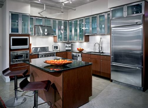 Appliance towers flank the workspace along the walls and obscure views of its counters from adjacent living areas.
