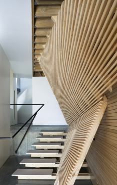 Canted poplar slats define a first-floor corridor.