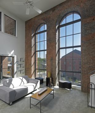 Large arched windows dictated double-height apartments, which are tucked into the steel trusses of the old mill.