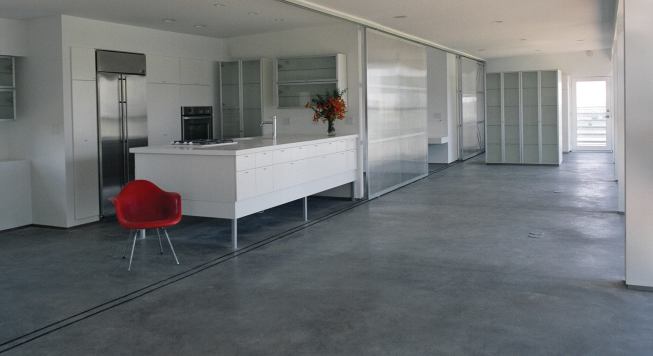 Polished concrete floors absorb heat generated by the glass wall during the day and then release the warmth as temperatures drop.