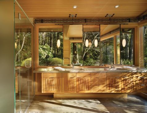 Over the sinks, architect Nils C. Finne added large mirrors, suspended in thin steel frames, that reflect patterns and light from the continuous windows behind them. They contribute a moment of glamour to an otherwise restrained room, and they do sway, underscoring the sense of hovering lightly in space. 

