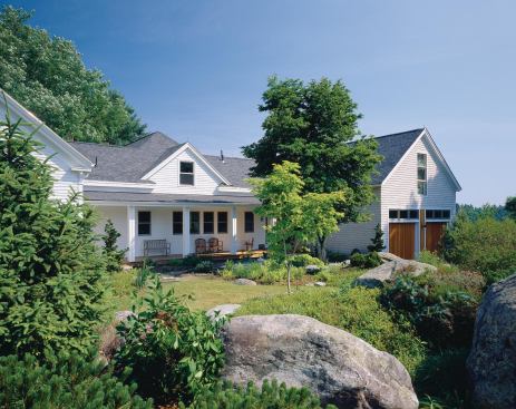 A new barn/garage and a reworked ell shift the focus of this house toward a lushly landscaped side yard.

