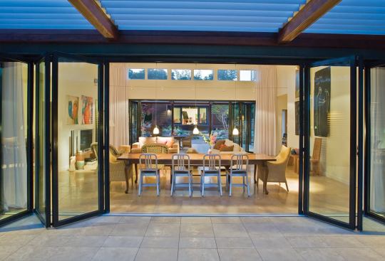 Accordion glass doors and floor-to-ceiling curtains allow the owners to control the air flow and privacy in the main living and dining area.