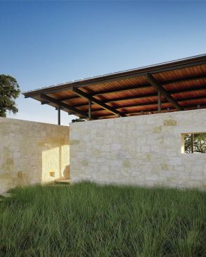 Perpendicular limestone “boxes” house the kitchen/media center and a storage area/bath with indoor-outdoor shower.