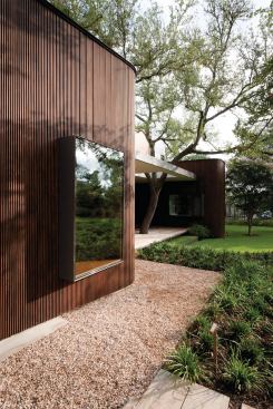 The garage includes a rounded element cladded in slatted wood that serves as interior storage, and that’s repeated several times on the home’s exterior. 