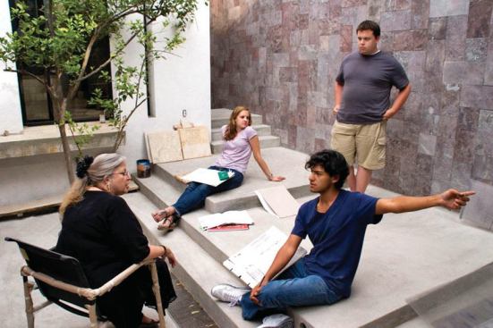 Cathi House talks with summer students at the new school and retreat center, which features a wall of indigenous volcanic stone.