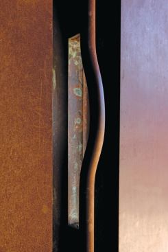 A sculptural door handle adds a handmade counterpoint to a project that’s strong in industrial materials.