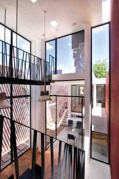 Light floods the 22-foot-high central studio with its glass-and-steel bridge. 