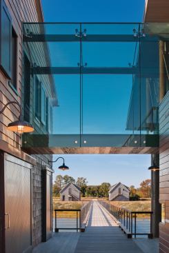 A steel-and-glass link ties together the home's two main portions, providing a vantage point for looking back at the mainland or out at the water.
