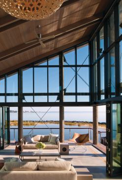 The double-height living room opens to the outdoor areas, creating a perfect venue for entertaining large groups. A concrete floor is outlined in wood for a rustic yet contemporary look.