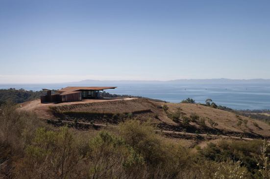 The house sits lightly on the land, and its fire-resistant glass, steel, and concrete exterior is designed to blend in.

