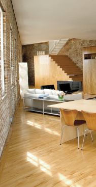 The free-standing island closest to the window wall has deep drawers on the interior side for dinnerware; the back is left open for counter seating that addresses the kitchen and living room. The other island houses appliances and extra storage on the liv