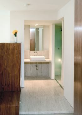 The shower alcove is lined in laminated glass, with a mirrored surface topped by a frosted film. "It gives the shower a foggy, ghostlike quality," Dumez says.