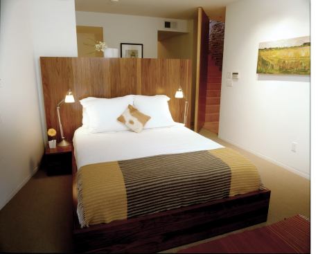 The master headboard screens the bathroom from view, yet keeps the compact space feeling open and roomy.