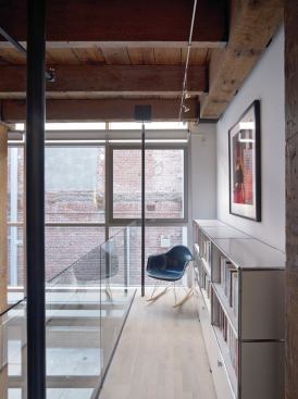A glass balcony on the mezzanine underscores the theme of transparency that pervades the one-bedroom dwelling. 