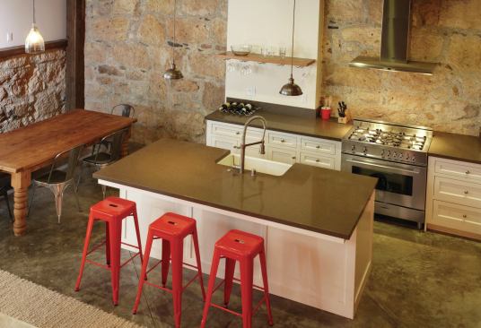 An impressive mix of materials work together in this kitchen:  Old stone, reclaimed fir, drywall, concrete, and Caesarstone