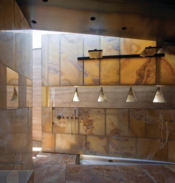 A hinged wall, clad in onyx and bisected by a band of glass, opens Desert Courtyard’s master bath to a private walled courtyard.