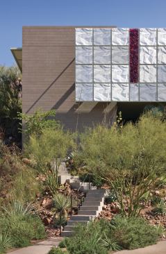 A screen of perforated aluminum panels anchors the Farrell Residence’s graphically simple entry facade. 