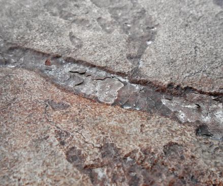This extreme closeup of a stamped joint shows excess release stuck to delaminating sealer.